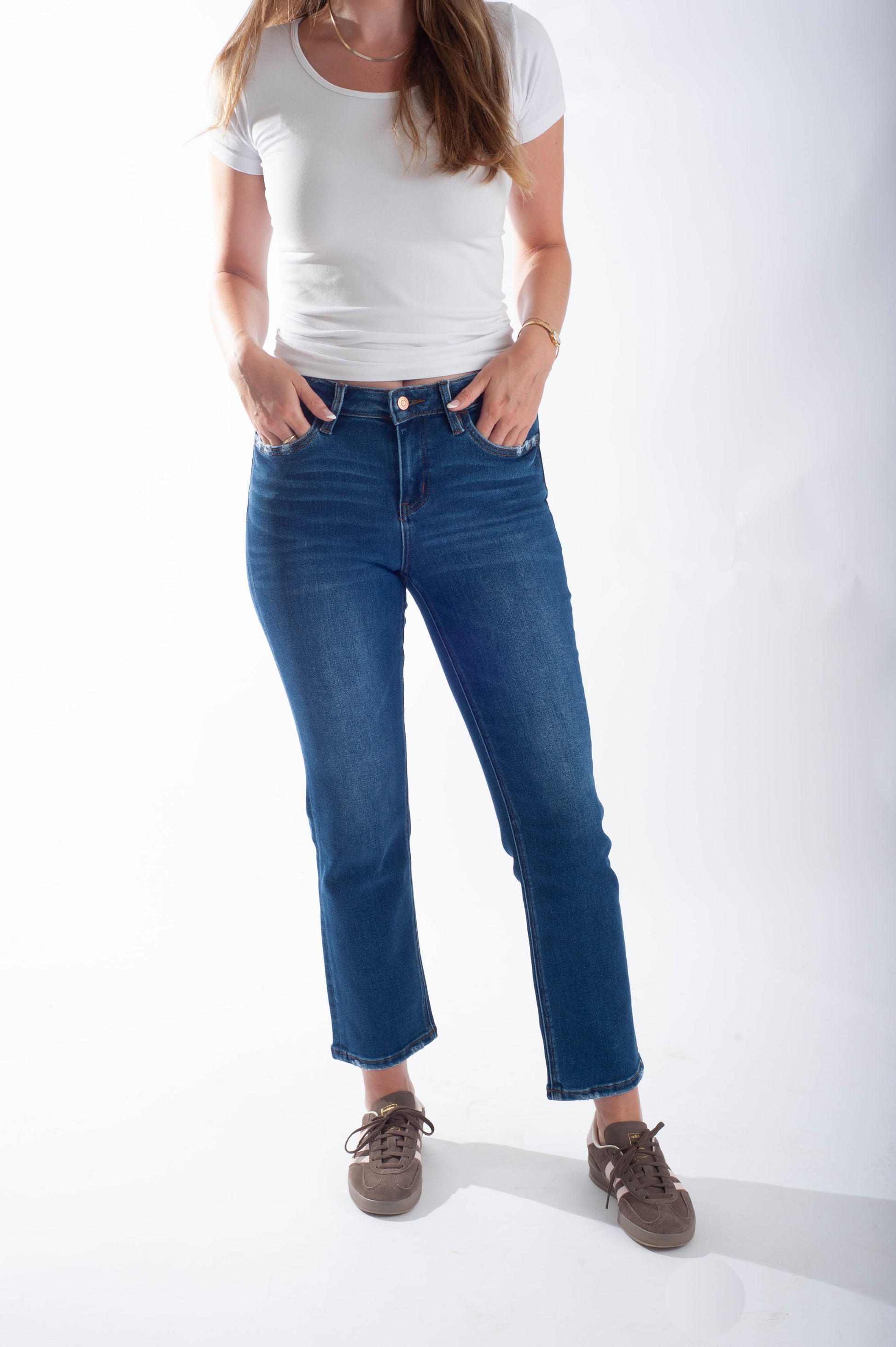 Person wearing blue jeans and a white t-shirt on a white background