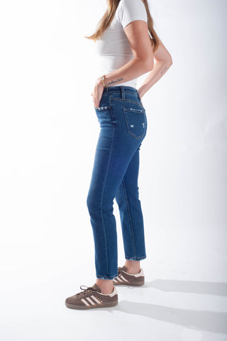 Person wearing blue jeans and a white top on a white background