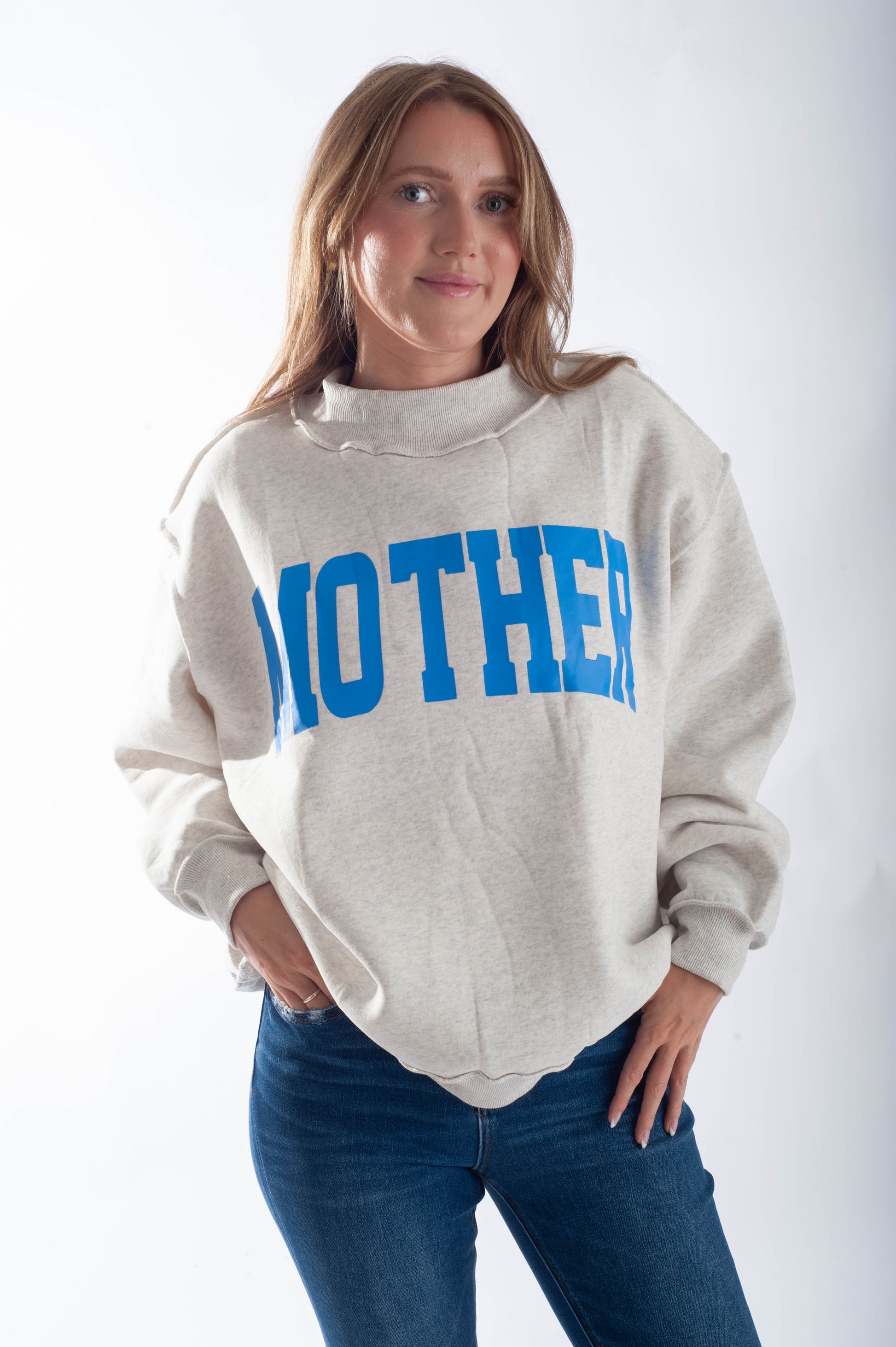 Person wearing a light gray hoodie with 'MOTHER' printed in blue on a white background