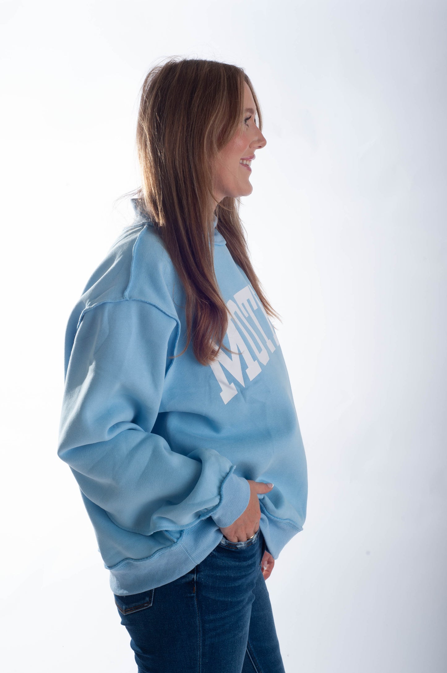 Woman wearing a light blue sweatshirt with text on a white background