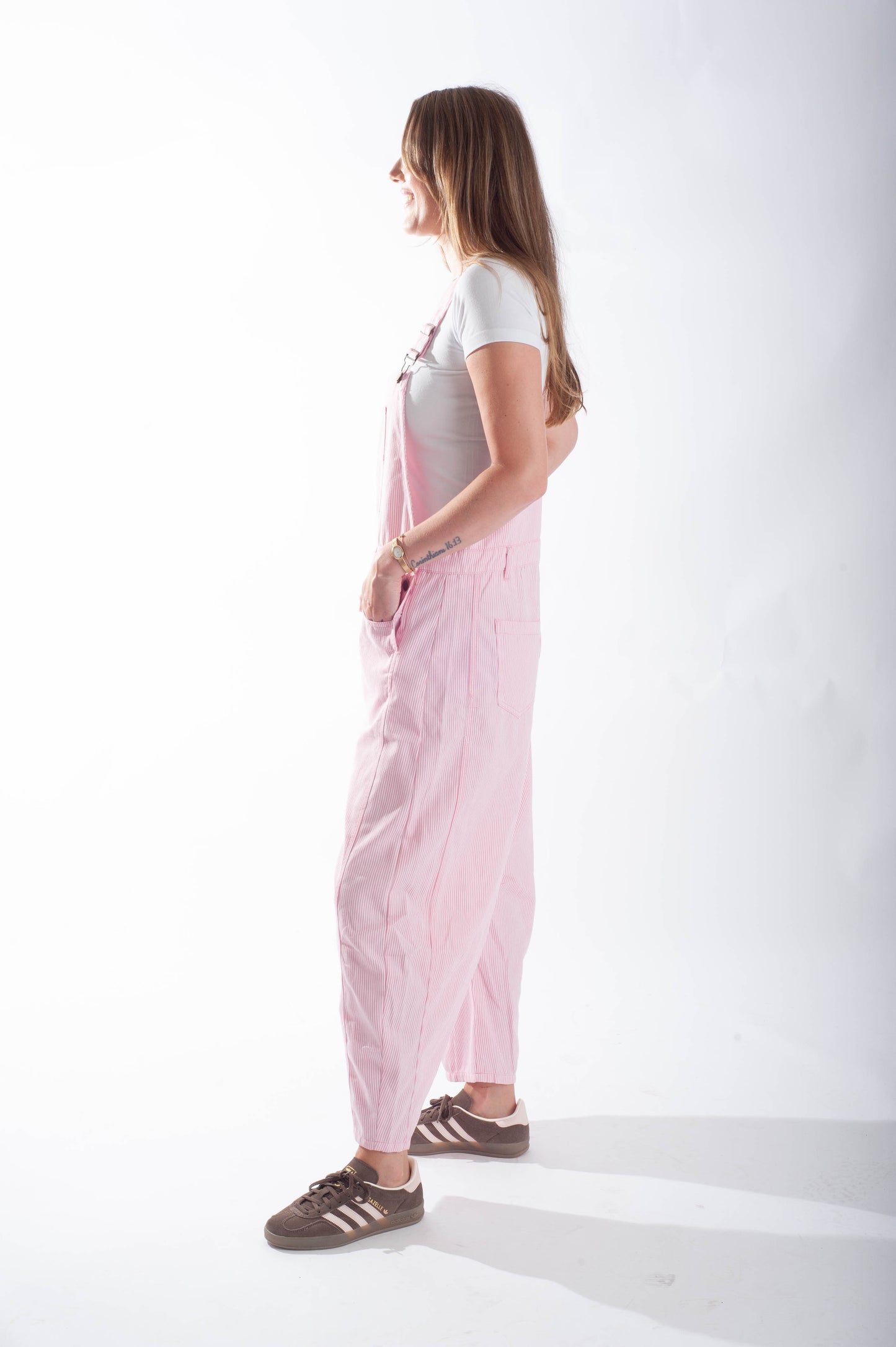 Woman wearing a pink dress with a white background
