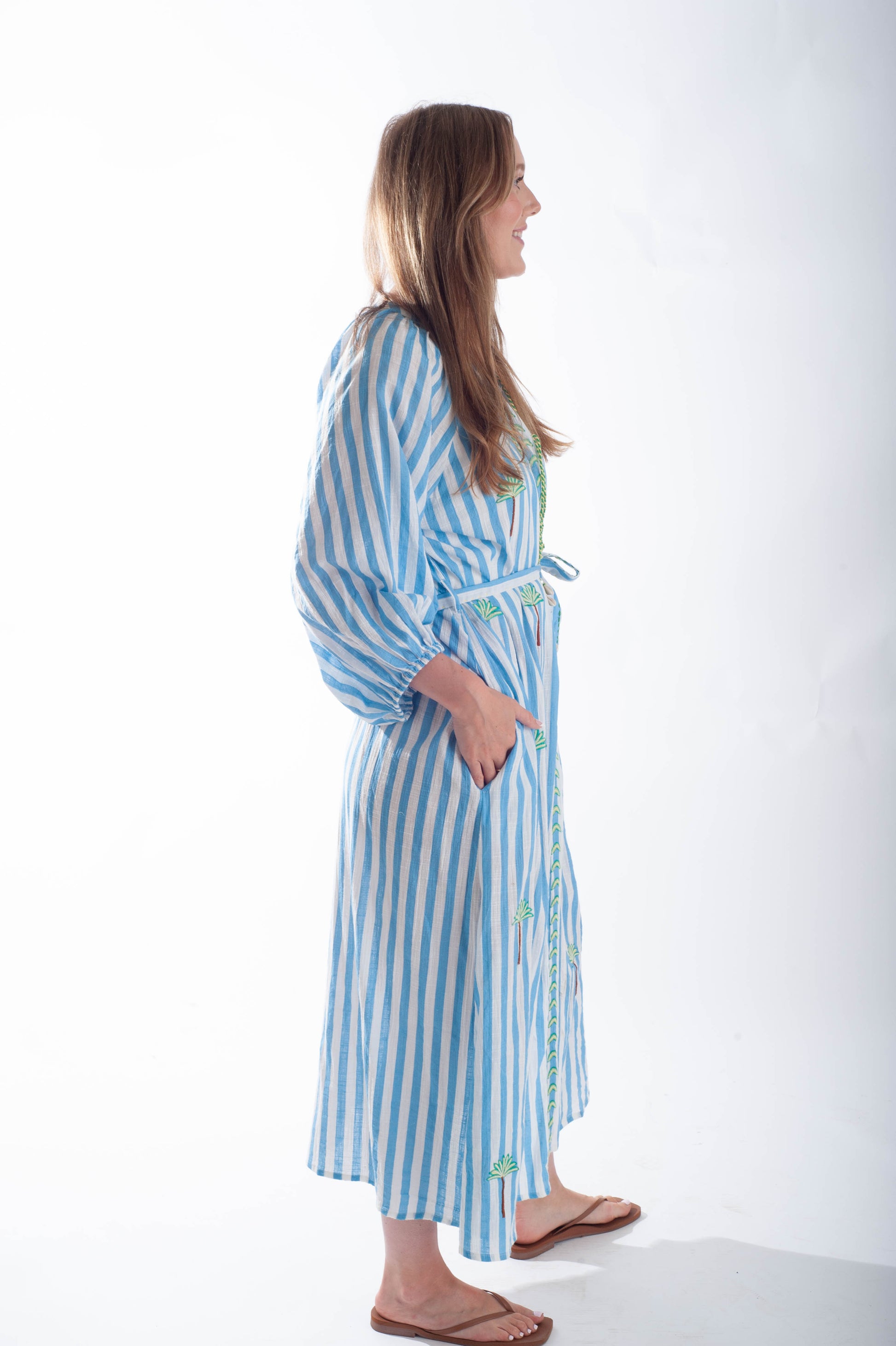 Woman wearing a blue and white striped robe on a white background