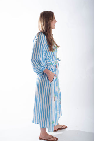 Woman wearing a blue and white striped robe on a white background