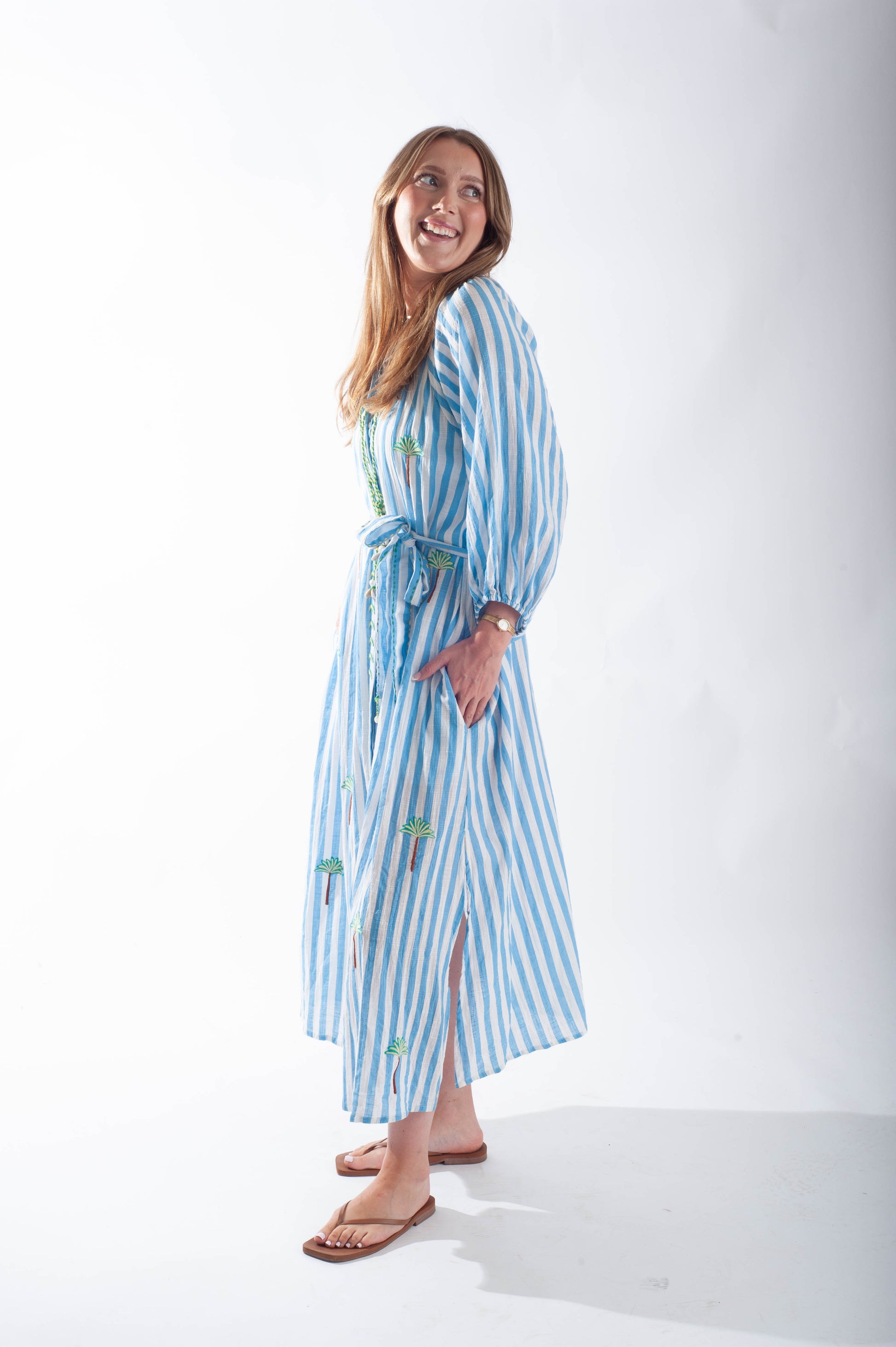 Woman wearing a blue and white striped dress on a white background
