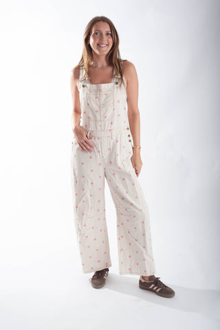 Woman wearing a white patterned overalls on a white background