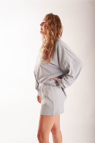 Women wearing striped shorts against a neutral background.