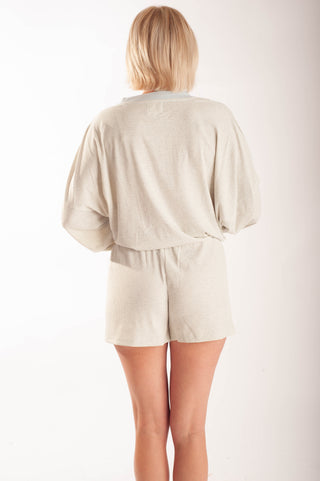 Women wearing striped shorts against a neutral background.