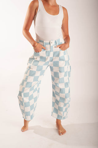 Women wearing bright coloured checker pants against a neutral background.