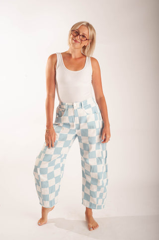 Women wearing bright coloured checker pants against a neutral background.