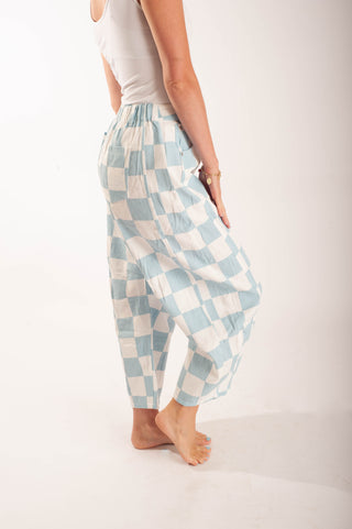 Women wearing bright coloured checker pants against a neutral background.