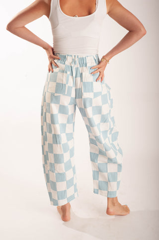 Women wearing bright coloured checker pants against a neutral background.