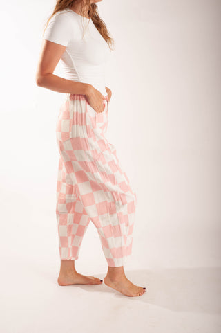 Women wearing bright coloured checker pants against a neutral background.