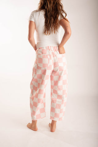 Women wearing bright coloured checker pants against a neutral background.