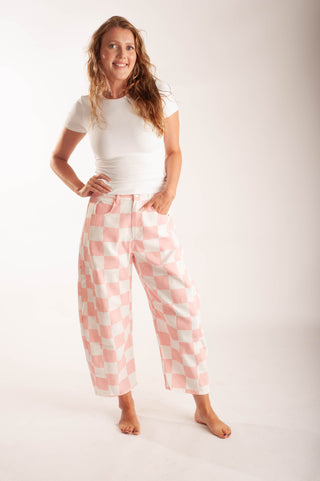 Women wearing bright coloured checker pants against a neutral background.