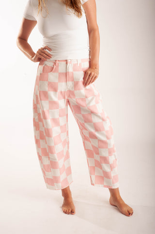 Women wearing bright coloured checker pants against a neutral background.