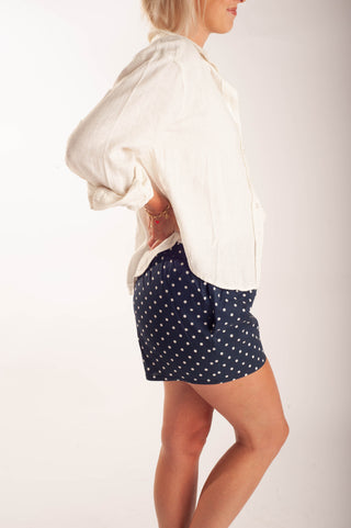 Women wearing polka dot boxer shorts against a neutral background.