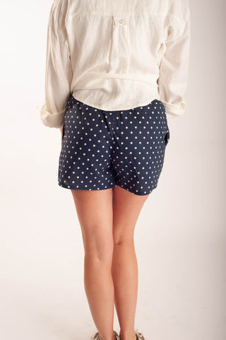 Women wearing polka dot boxer shorts against a neutral background.