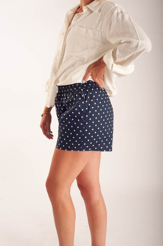 Women wearing polka dot boxer shorts against a neutral background.