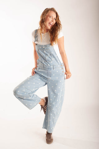 Women wearing polka dot overalls against a neutral background.