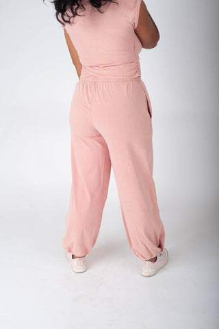 Person wearing a pink jumpsuit on a white background