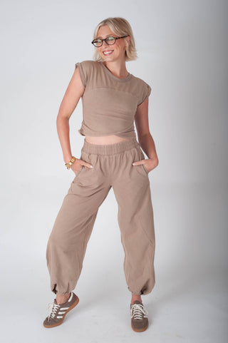 Woman wearing a beige outfit on a white background