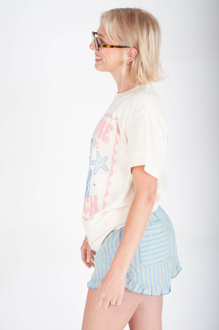 Woman wearing a graphic t-shirt and striped shorts on a white background