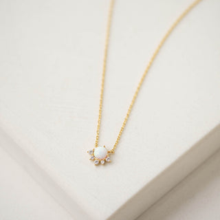 Gold necklace with a pendant on a beige background