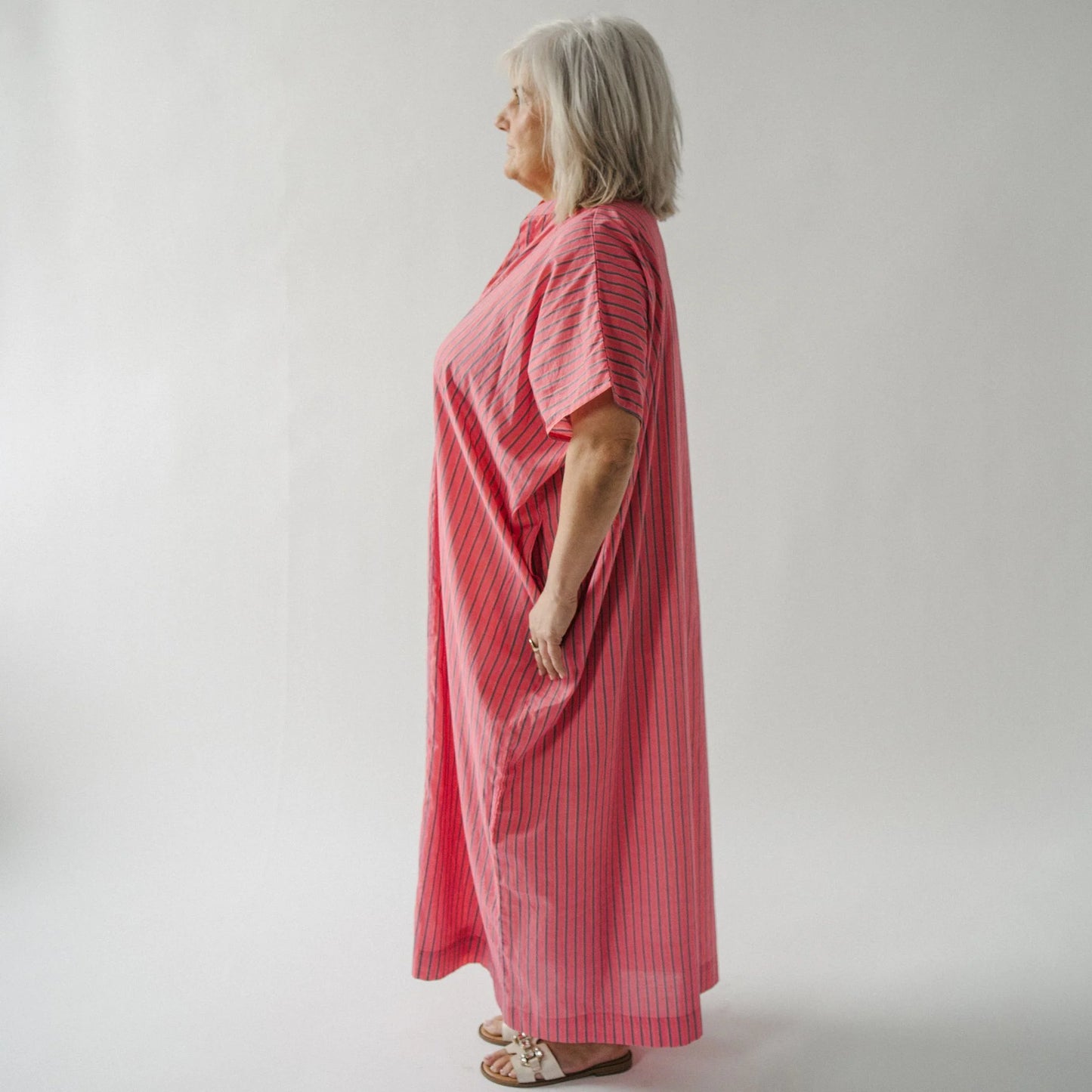 Woman wearing a pink dress against a plain background