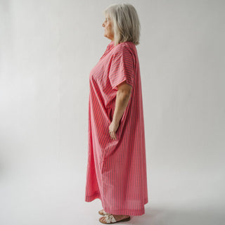 Woman wearing a pink dress against a plain background