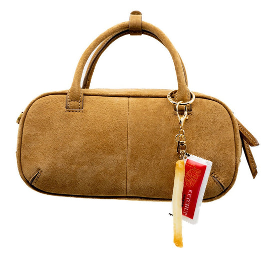 Brown handbag with a keychain and tag on a white background