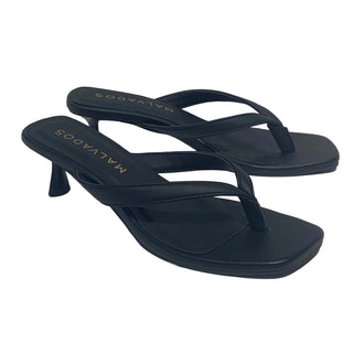 Pair of black high-heeled sandals on a white background