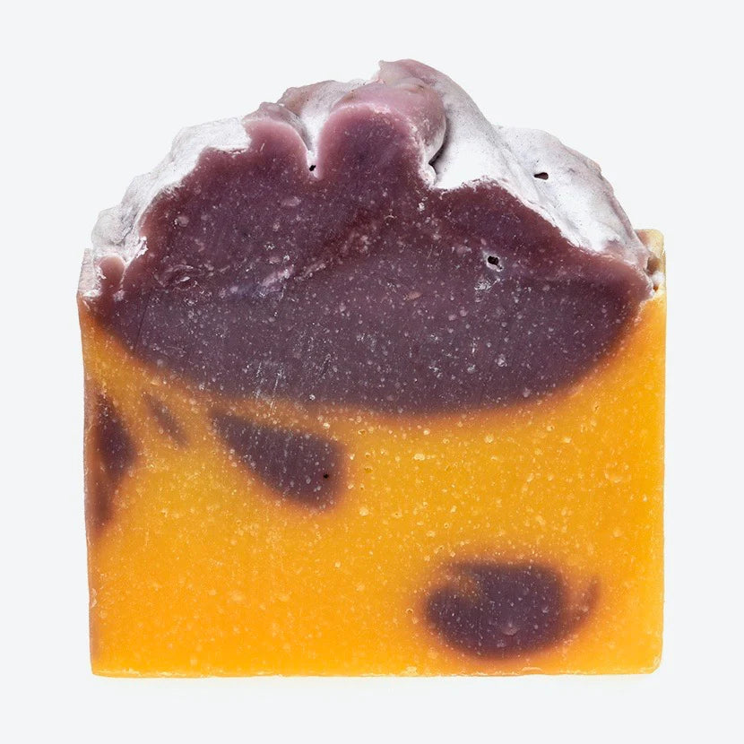 Bar of soap with purple and orange layers on a white background