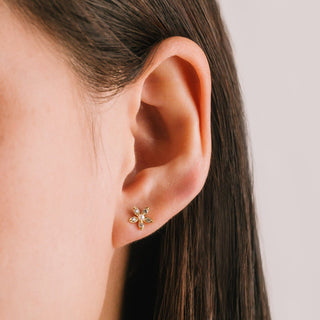 flower shaped stud earrings on a person