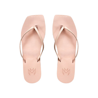 Pair of pink flip-flops with a brand logo on a white background