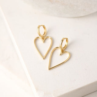 a pair of large gold heart shaped drop earrings