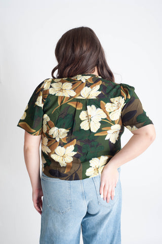Person wearing a floral blouse with a white background