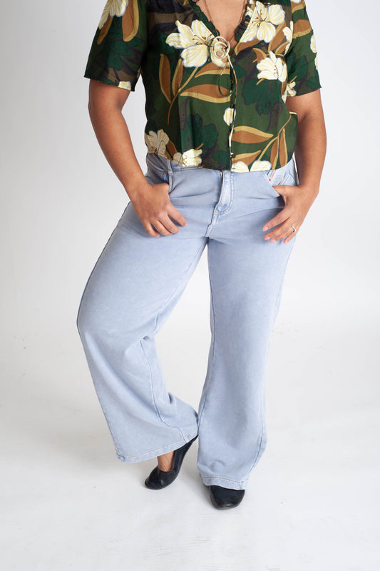 Person wearing a floral shirt and light blue jeans on a white background