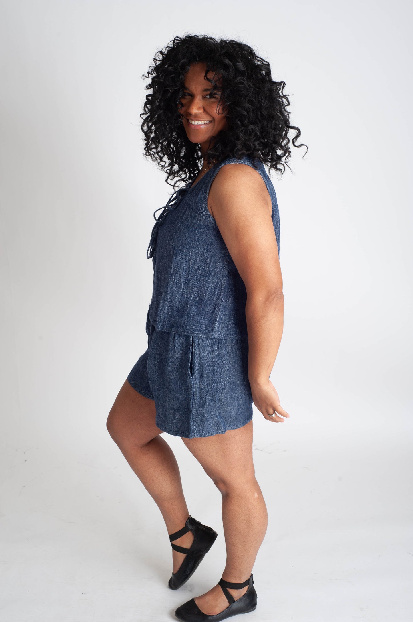 Woman wearing a denim romper on a white background