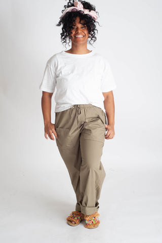 Woman wearing a white t-shirt and beige pants on a white background