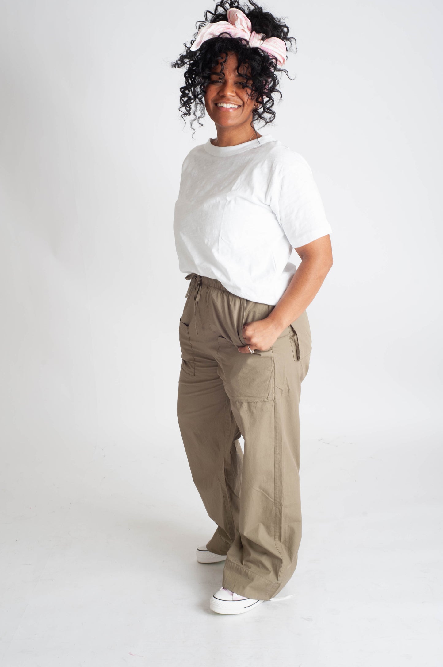 Person wearing a white shirt and beige pants on a white background