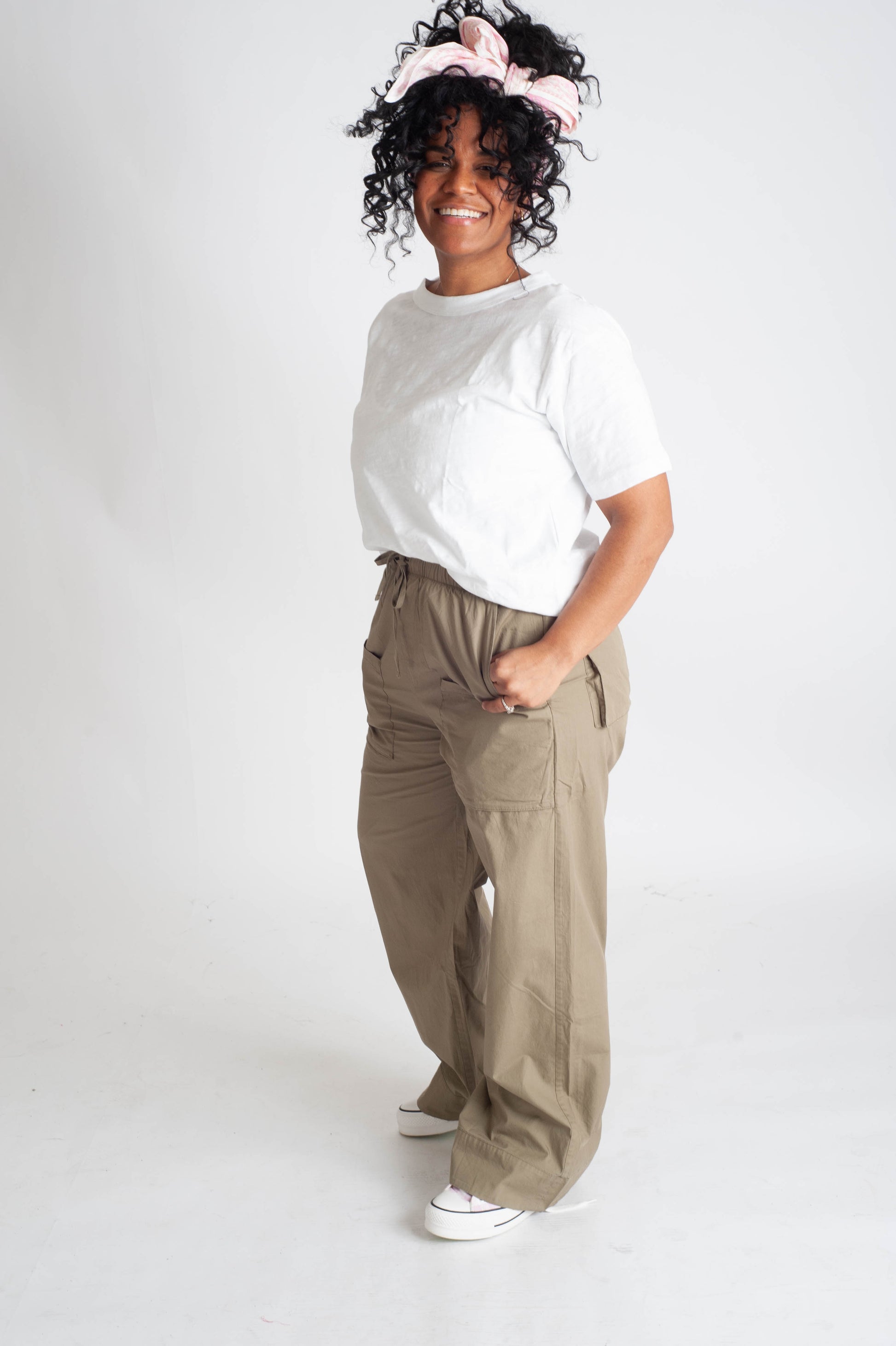 Person wearing a white shirt and beige pants on a white background