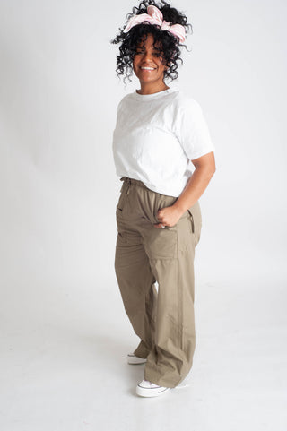 Person wearing a white shirt and beige pants on a white background