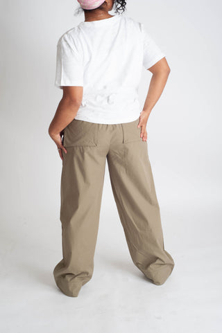Person wearing a white t-shirt and beige wide-leg pants on a white background