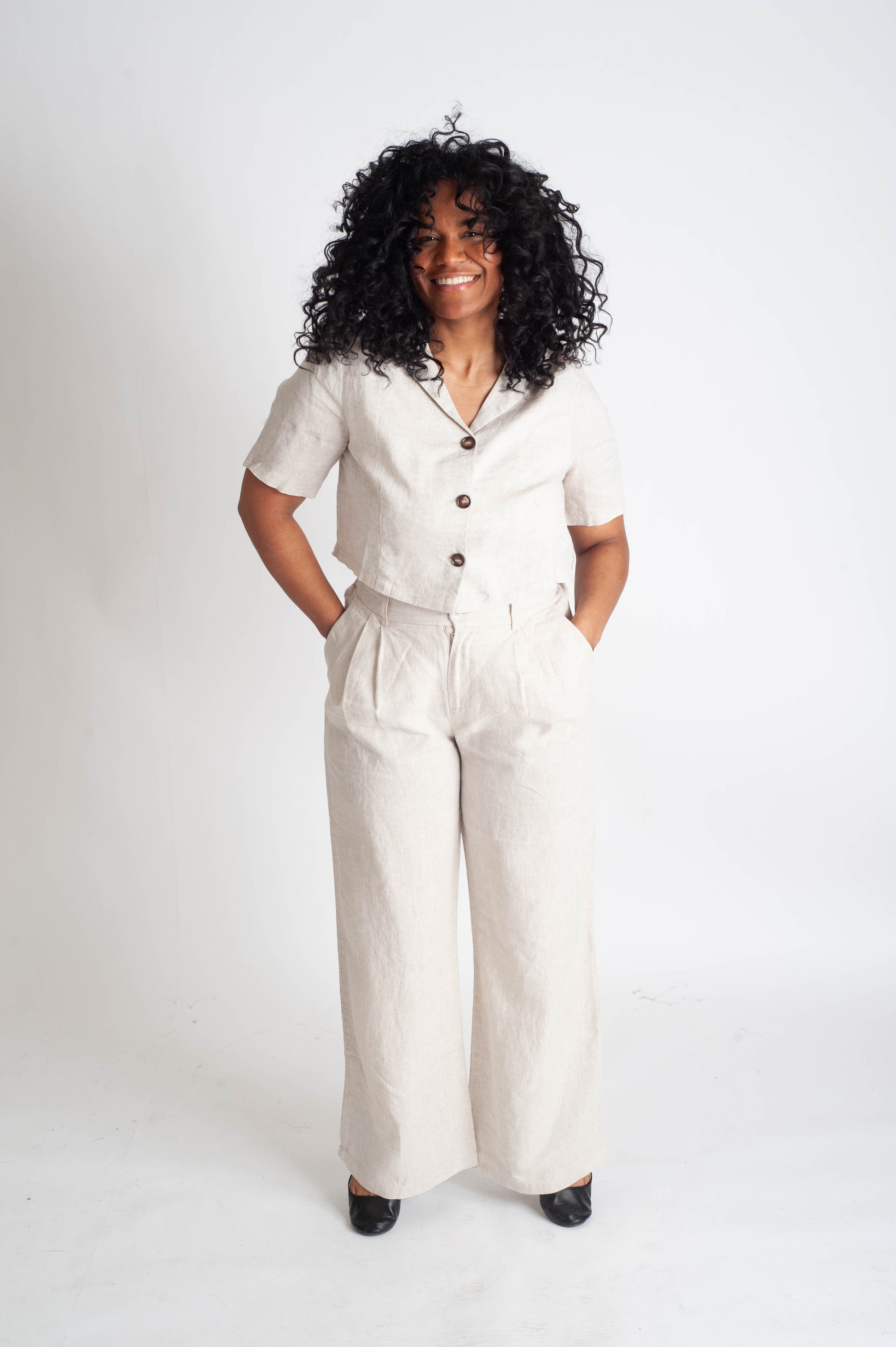 Woman wearing a white outfit with buttons on a white background