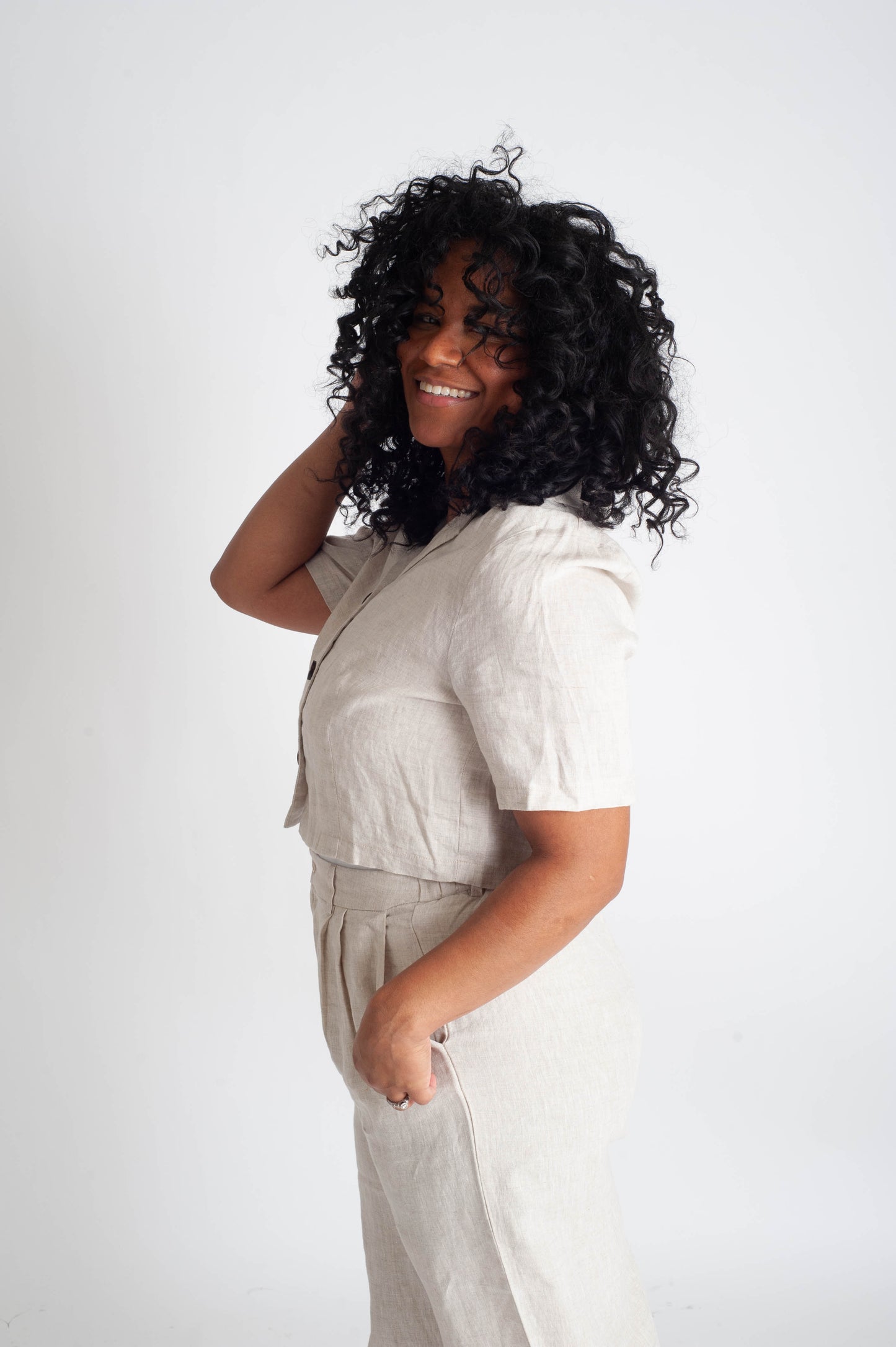Woman wearing a beige outfit against a white background