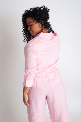 Woman wearing a pink outfit against a plain background