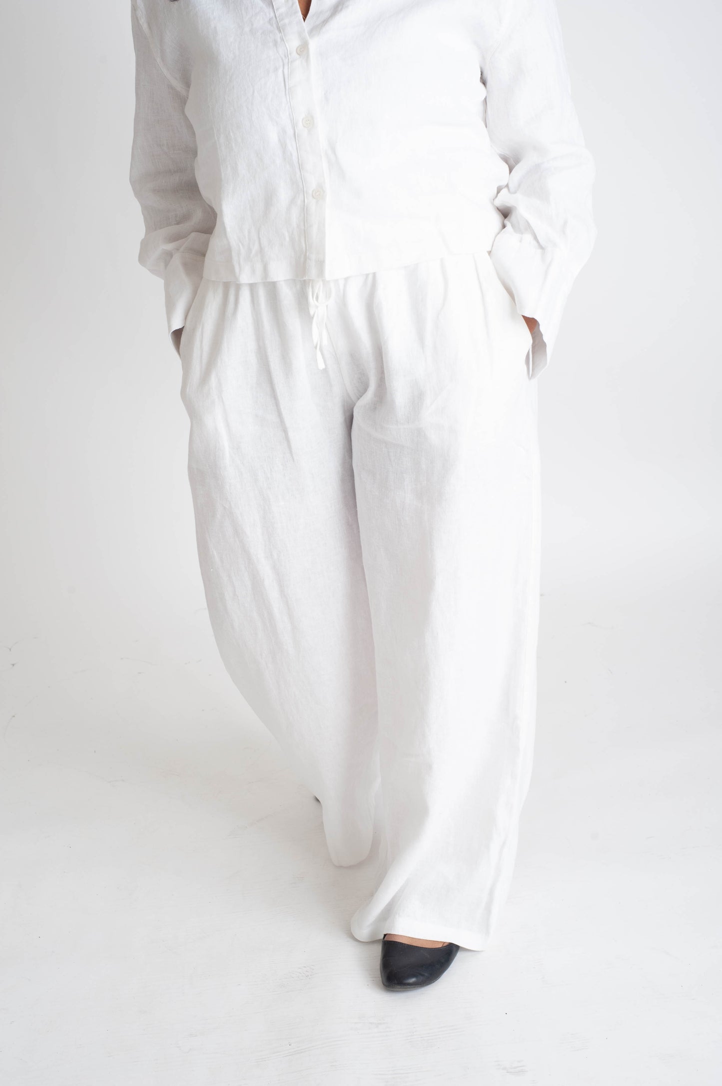 Person wearing a white outfit on a plain background
