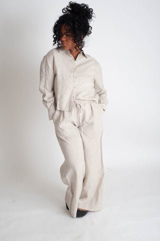 Woman wearing a beige linen outfit on a white background