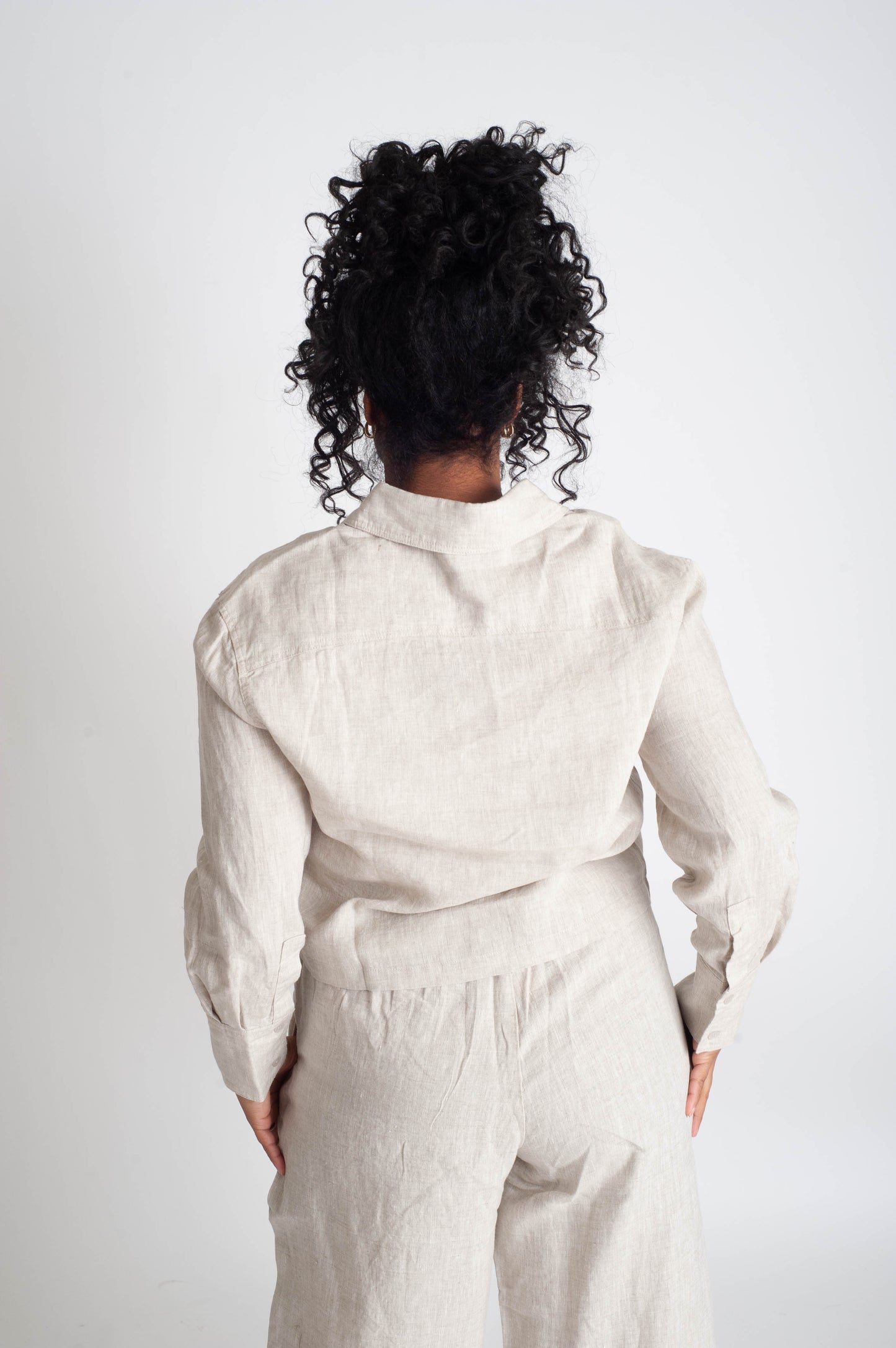 Person wearing a white outfit against a plain background