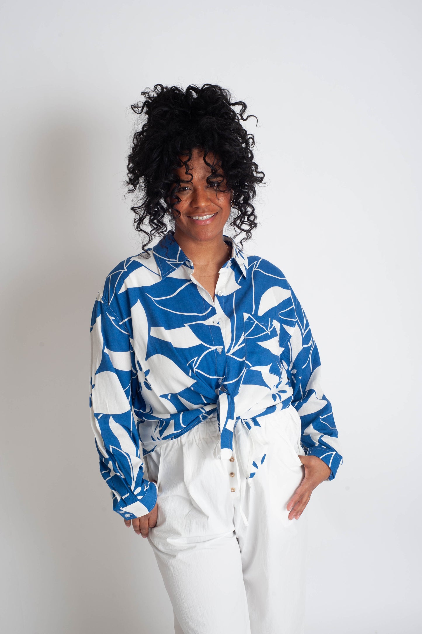 Person wearing a blue and white patterned shirt with a plain background